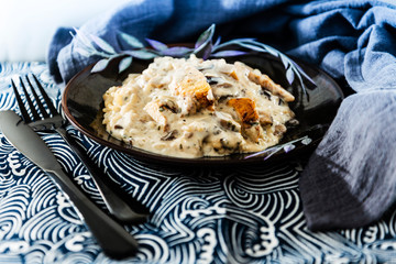 Tasty risotto with chicken, fresh herbs vegetables on a white plate