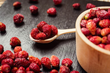 red strawberries in bowl on a wooden background