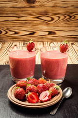healthy strawberry yogurt with fresh berries on old wooden background