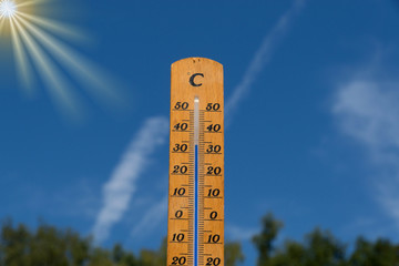 Naklejka premium Thermometer im Sommer mit blauen Himmel im Hintergrund
