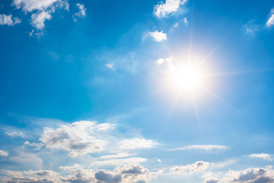 Summer background, blue sky with white clouds and sun