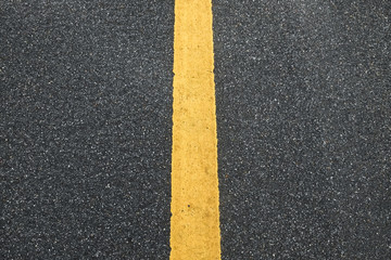 Fototapeta premium Surface rough of asphalt, Grey with yellow line on the road and small rock, Texture Background