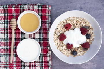 Breakfast meal with a bowl of muesli with yogurt and honey 