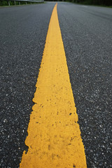 Surface rough of asphalt, Grey with yellow line on the road and small rock, Texture Background