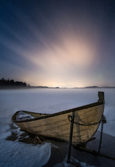Scenery nightscape with wooden boat and moody atmosphere at winter night in Finland