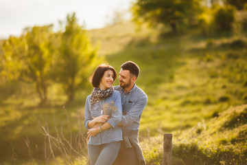 couple hugging in green garden in the spring at sunset