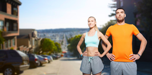 Fototapeta premium fitness, sport and healthy lifestyle concept - happy couple exercising in summer over san francisco city background
