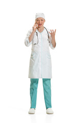 Beautiful young woman in white coat posing at studio. Full length studio shot isolated on white.