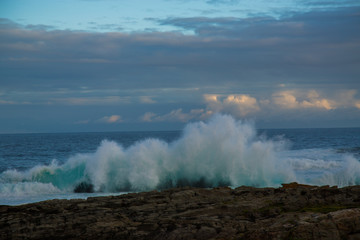 Blue waves breaking over rocks