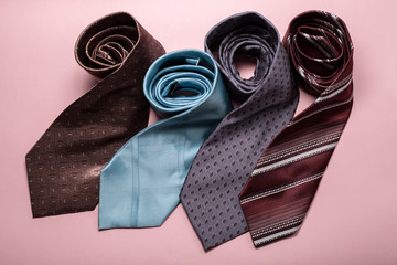 different men's ties on pink background