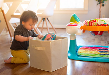 Happy toddler boy playing with toys in his house