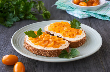 Toast with cheese and yellow tomatoes on a plate 