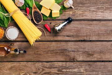 Fototapeta na wymiar Pasta and ingredients on wooden background with copy space. Top view. Vegetarian food, healthy or cooking concept.