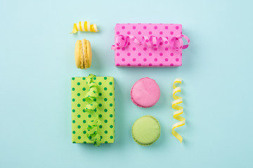 Festive flat lay with Gift boxes & colorful macarons on light blue background