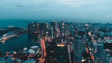Naklejka premium Aerial view of Singapore skyscrapers with city skyline during cloudy evening