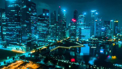 Aerial drone view of Singapore skyscrapers with city skyline at night