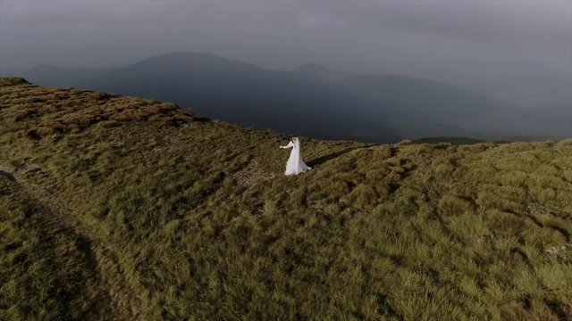 beautiful wedding couple walks in mountains aerial view 4k