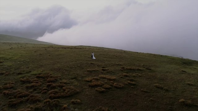 beautiful wedding couple walks in mountains aerial view 4k