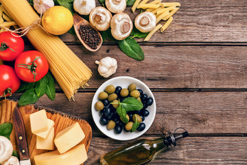 Ingredients for spaghetti with basil, tomatoes, cheese on wooden background, top view, place for text