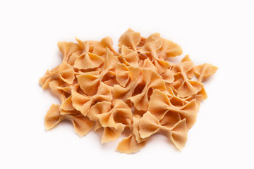 Heap of orange farfalle pasta isolated on white