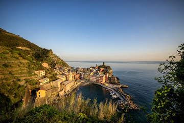 Fototapeta na wymiar Vernazza fisherman village at sunset. Vernazza is one of five famous colorful villages of Cinque Terre in Italy, suspended between sea and land on sheer cliffs. Liguria, Italy