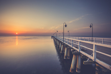 Naklejka premium Amazing colorful sunrise over the pier in Gdynia Orlowo. Sunrise over the sea.
