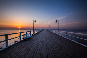 Fototapeta na wymiar Amazing colorful sunrise over the pier in Gdynia Orlowo. Sunrise over the sea.