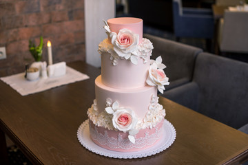 Obraz na płótnie Canvas Beautiful elegant four tiered pink wedding cake decorated with roses flowers. Concept floral from sugar mastic