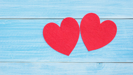 Obraz na płótnie Canvas Red fabric heart on a blue wooden table.