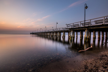Fototapeta premium Niesamowity kolorowy wschód słońca nad molo w Gdyni Orłowie. Wschód słońca nad morzem.