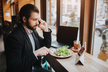 Busy man is in a hurry, he does not have time, he is going to eating and working. Worker eating,...