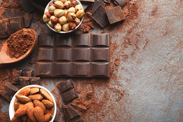 Crushed chocolate bar pieces and cocoa on gray background