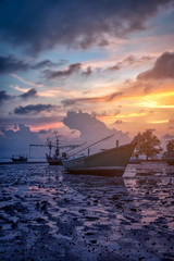 Silhouettes fishing boat and tree at sunset time, Phuket, Thailand.