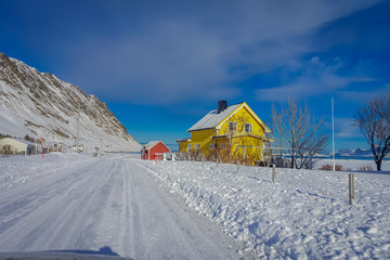 Outdoor view of wooden houses partial covered with snow in Lofoten islands