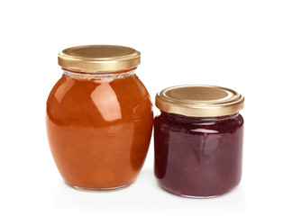 Two jars with tasty sweet jam on white background