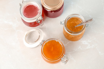 Jars with different sweet jam on table