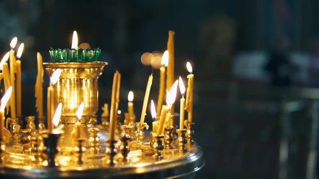 atmosphere of the Christian church, many candles burn, slow-motion shooting, smooth movement, camera slide, icons and religion, concept sacred rituals, wedding, baptism, communion, prayers to God