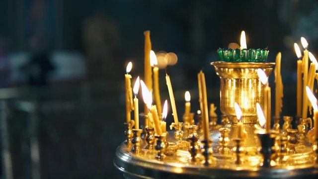 atmosphere of the Christian church, many candles burn, slow-motion shooting, smooth movement, camera slide, icons and religion, concept sacred rituals, wedding, baptism, communion, prayers to God