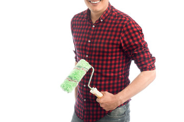 Smiling young European man with a roller, a house painter in a plaid shirt