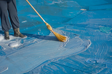 worker cleans the bottom of a large pool