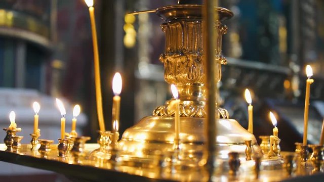 atmosphere of the Christian church, many candles burn, slow-motion shooting, smooth movement, camera slide, icons and religion, concept sacred rituals, wedding, baptism, communion, prayers to God