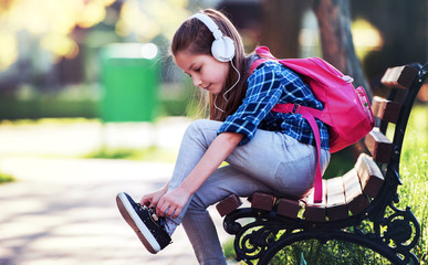 Schoolgirl tying shoes. Education, lifestyle concept - Powered by Adobe