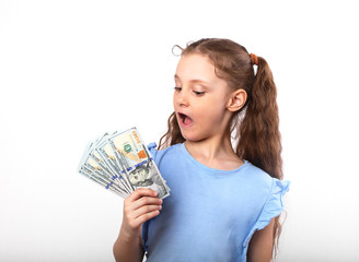 Happy smiling kid girl holding money with surprising emotion and opened mouth on white background with empty copy space