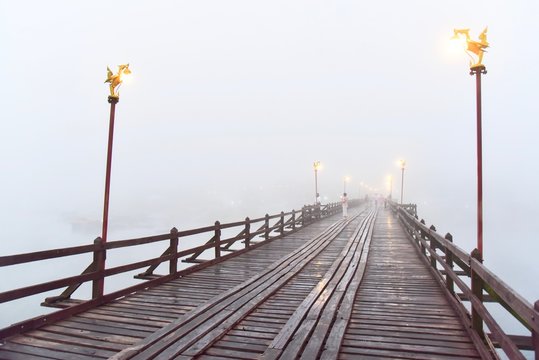 View of Wooden Mon Bridge on a Hazy Morning Day