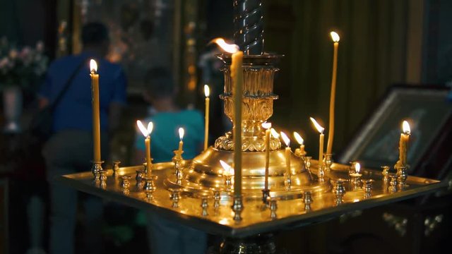 atmosphere of the Christian church, many candles burn, slow-motion shooting, smooth movement, camera slide, icons and religion, concept sacred rituals, wedding, baptism, communion, prayers to God