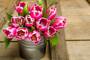 Pink tulip bouquet on retro wooden background, copy space