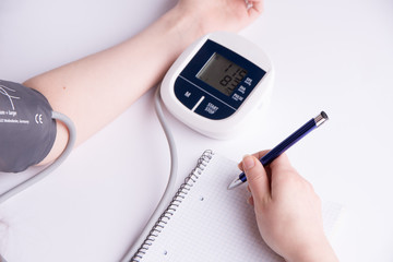 Measuring blood pressure. The doctor records the results. White background