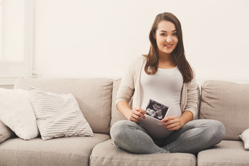 Pregnant woman looking at her baby sonography