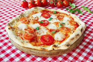 Italian Pizza Margherita with mozzarella, fresh tomatoes and marjoram