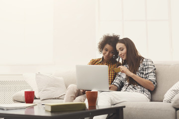 Two women online with credit card and laptop
